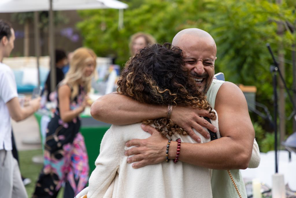 Joyful embrace between two participants at an ƎVOLVE community gathering