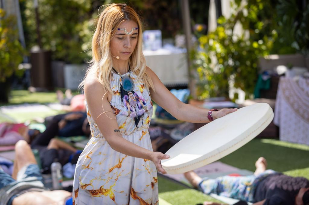 Sound healing facilitator at an outdoor ƎVOLVE retreat